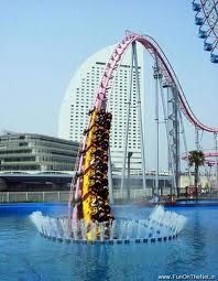 several people ride on a roller coaster in an amusement park with water splashing behind them