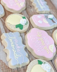 decorated cookies on a wooden table with writing and flowers in the middle one cookie has been cut out to look like lemonade