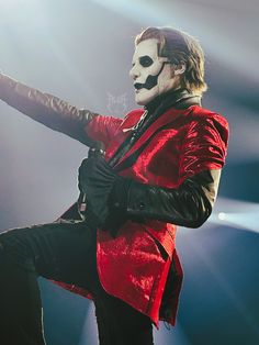 a man in a red jacket and mask on stage