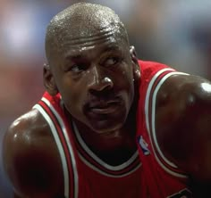 a close up of a basketball player wearing a red jersey and looking at the camera