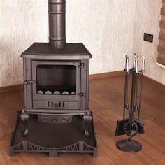 an old fashioned wood stove sitting on top of a hard wood floor next to two poles