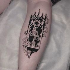 a black and white photo of a tattoo with a book shelf on it's leg