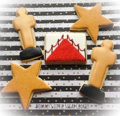 decorated cookies are arranged in the shape of stars and pyramids on a striped tablecloth