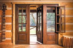 an open wooden door in a log cabin