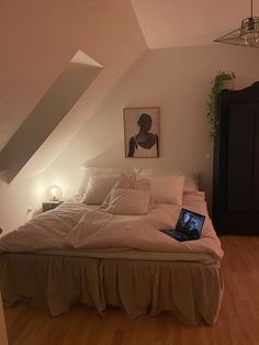 a laptop computer sitting on top of a bed in a bedroom next to a dresser