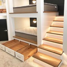 there is a bunk bed in the middle of some stairs with drawers underneath it and lights on either side