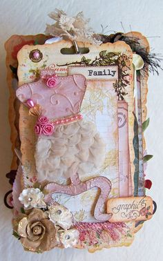 a card with a sheep and flowers on it's side, hanging from a wall