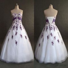 two dresses with purple flowers on them, one is white and the other is black