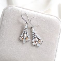 Elegant & full of shimmer, our dainty earrings are perfect for any special occasion. These earrings feature genuine Austrian crystals and just a touch of pearls. - Handcrafted with genuine Austrian crystals - Each stone is set by hand in my studio - Golden shadow, white opal and clear stones - Cream pearls - Antique silver finish pictured - Available in antique gold or antique silver finishes - Earrings measure 1.75 inch  - Handcrafted in the US. - Nickel free and hypoallergenic - PLEASE ALLOW A White Crystal Earrings With Elegant Design For Party, White Sparkling Crystal Earrings For Anniversary, White Chandelier Earrings With Sparkling Stones For Gift, Glamorous Sparkling White Bridal Earrings, Sparkling Dangle Cluster Earrings For Wedding, White Sparkling Crystal Bridal Earrings, Formal White Sparkling Teardrop Earrings, Wedding Diamond Earrings With Rhinestones, Formal White Sparkling Crystal Earrings