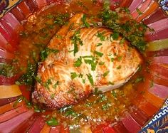 a close up of a plate of food with meat and vegetables in sauce on it