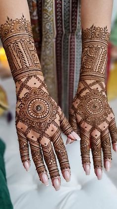 two hands with henna tattoos on them