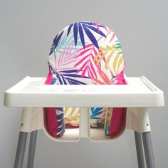 a high chair with a colorful seat cover on it