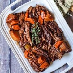 a white plate topped with roast and carrots