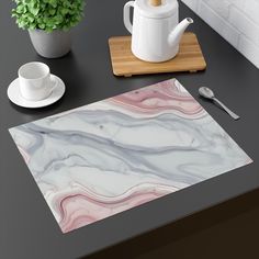 a table with a teapot, cup and saucer on it next to a cutting board