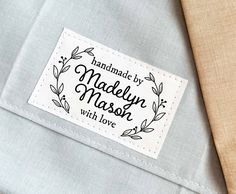 a label on the back of a suit with a tie around it that says, handmade by madam mason with love