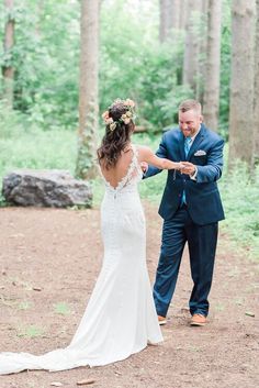 a bride and groom dancing in the woods