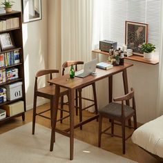 a living room with a table and chairs next to a book shelf filled with books