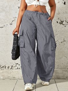 Spring Baggy Cargo Pants With Drawstring, Spring Baggy Drawstring Cargo Pants, Trendy Gray Parachute Pants With Pockets, Baggy Utility Cargo Pants With Drawstring, Trendy Gray Pants With Drawstring, Utility Nylon Cargo Pants With Drawstring, Utility Parachute Pants With Drawstring And Relaxed Fit, Utility Parachute Pants With Drawstring, Baggy Utility Parachute Pants With Functional Drawstring