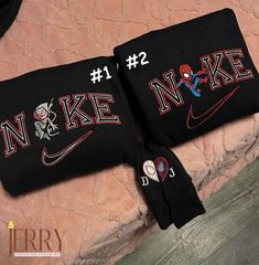 two black nike wristbands with spiderman on them sitting on a pink blanket