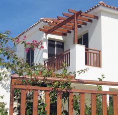 a white house with brown trim and wooden railing