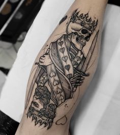 a man with a tattoo on his arm holding a knife and skull in the background