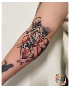 a person with a tattoo on their arm that has an image of the joker and cat