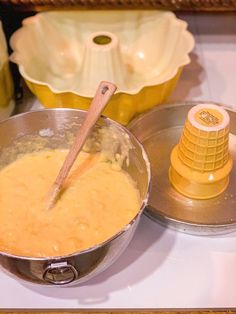 a metal bowl filled with batter on top of a stove