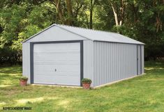 a gray garage sitting on top of a lush green field