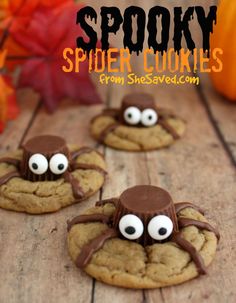 spider cookies with googly eyes and chocolate on top, sitting on a wooden table