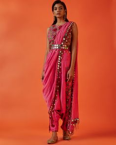 This Fuschia rose set features a scoop neck sleeveless blouse embroidered with a garden of maroon flowers. Paired with embroidered dhoti pants and a pre-stitched mirror dupatta. Finished off with a mirror belt with tassel detailing. Delivery Time: Since this piece is made to order, please allow 4-6 weeks for your outfit to arrive from India. Included In Purchase: Blouse, Pants, Dupatta, Belt Care & Composition: Dry Clean Only, Cotton Chanderi Return Policy: All made to order items are final sale Dhoti Style Dresses, Dhoti Dresses For Women, Diwali Dresses, Diwali Outfits, Full Sleeve Blouse, Saree Gown, Gown Pattern, Embellished Blouse