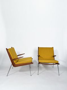 two yellow chairs sitting next to each other on a white background in front of a wall