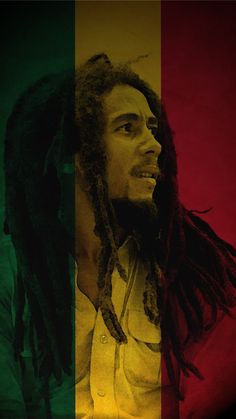 a man with dreadlocks standing in front of a multicolored wallpaper