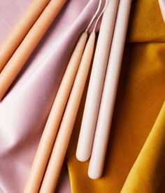 four wooden dowels laying on top of a yellow and pink cloth next to each other