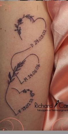 two hearts with arrows and names tattooed on the side of a woman's thigh