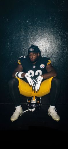 a football player is sitting down with his legs crossed