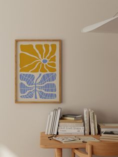 a table with some books on top of it and a painting hanging above the table