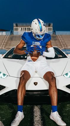 a football player sitting in front of a sports car