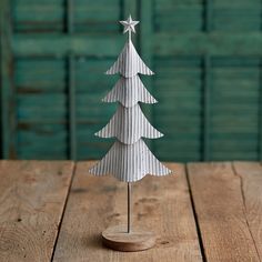 a small white christmas tree sitting on top of a wooden table