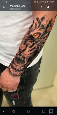 a man's arm with a tiger tattoo on it and an orange eye in the center