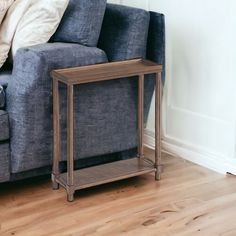 a blue couch sitting next to a wooden table on top of a hard wood floor