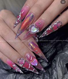 a woman's nails with pink and silver designs on them, including an acrylic design