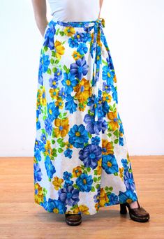 "This is a beautiful and bright 1970s vintage \"Leslie Fay\" maxi skirt with a Hawaiian floral print and a matelassé weave! It's a wrap skirt with two buttons at the waist and an attached long fabric sash. It has interesting box pleats in the back that give it added volume. The weave is textured with white on white jacquard flowers and a bright blue, blue-purple, chartreuse green and sunny gold tropical design. Perfect for summer pool parties, or wear as a beach cover-up over your swimsuit! The Hippie Floral Print Maxi Skirt For The Beach, Retro Blue Floral Print Skirt, Blue Retro Skirt With Floral Print, Hippie Blue Maxi Skirt For The Beach, Vintage Beach Skirt For Spring, Vintage Floral Print Maxi Skirt For Summer, Retro Spring Flowy Maxi Skirt, Spring Beach Full-length Maxi Skirt, Spring Beach Maxi Skirt Full Length