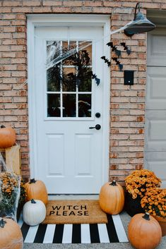 a front door decorated for halloween with pumpkins