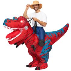 a man riding on top of a inflatable t - rexe with a cowboy hat