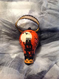 an ornament that is on top of a white netted cloth with a black and orange design