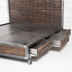 the bed has two drawers on each side and is made out of wood with metal handles