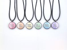 five different necklaces with words on them