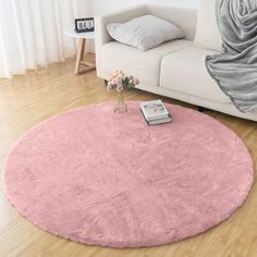 a living room with a white couch and pink rug