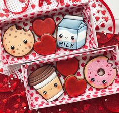 two boxes filled with donuts and doughnuts on top of red paper hearts