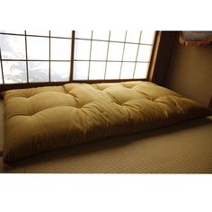 a futon mattress sitting in front of a window